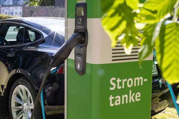 Ein Auto wird an einer E-Ladesäule aufgetankt.